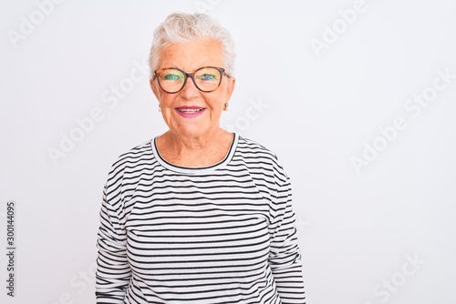 Senior grey-haired woman wearing striped navy t-shirt glasses over isolated white background with a happy and cool smile on face. Lucky person.