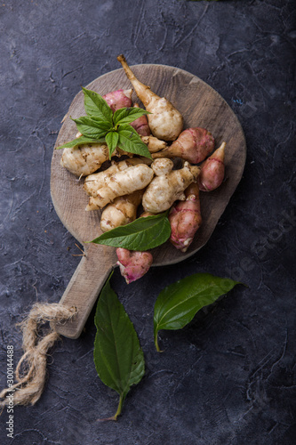 Jerusalem artichokes or topinambour, (topinambur), also known as earth apple or sunroot on a cutting board. Dietaryfibre