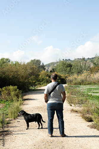 Hombre paseando con su perro por el campo. © Lola Fdez. Nogales