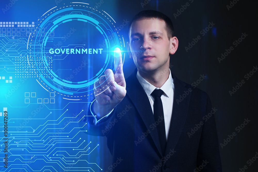 Business, Technology, Internet and network concept. Young businessman working on a virtual screen of the future and sees the inscription: Government Business, Technology, Internet and network concept. Young businessman working on a virtual screen of the future and sees the inscription: Government