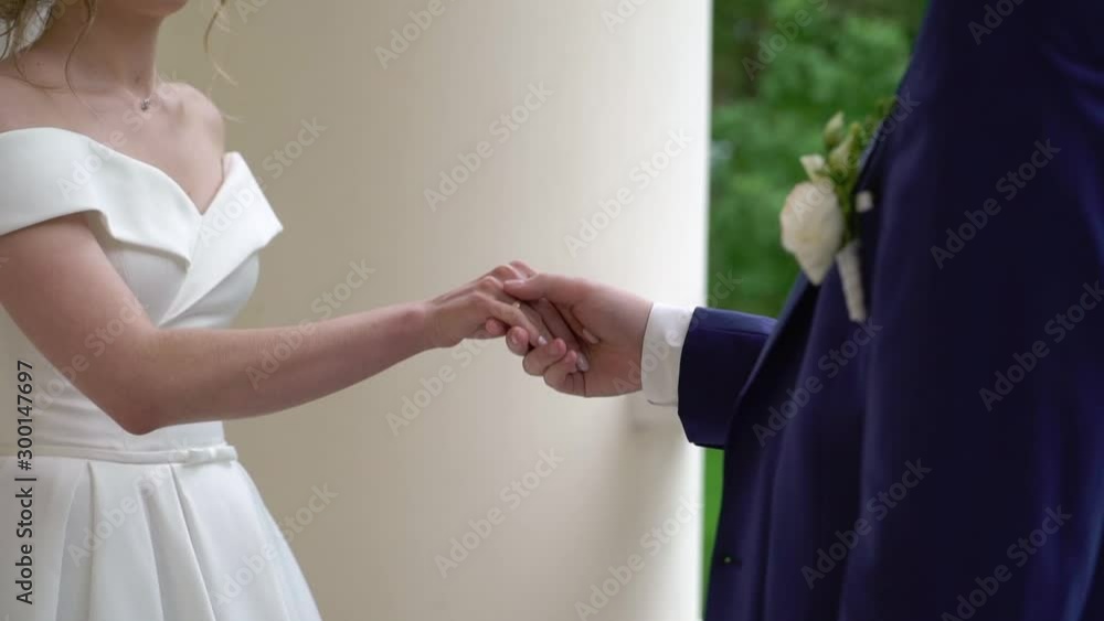Wedding couple in a park. Bride and groom holding hands. Wedding couple in a park. Bride and groom holding hands.