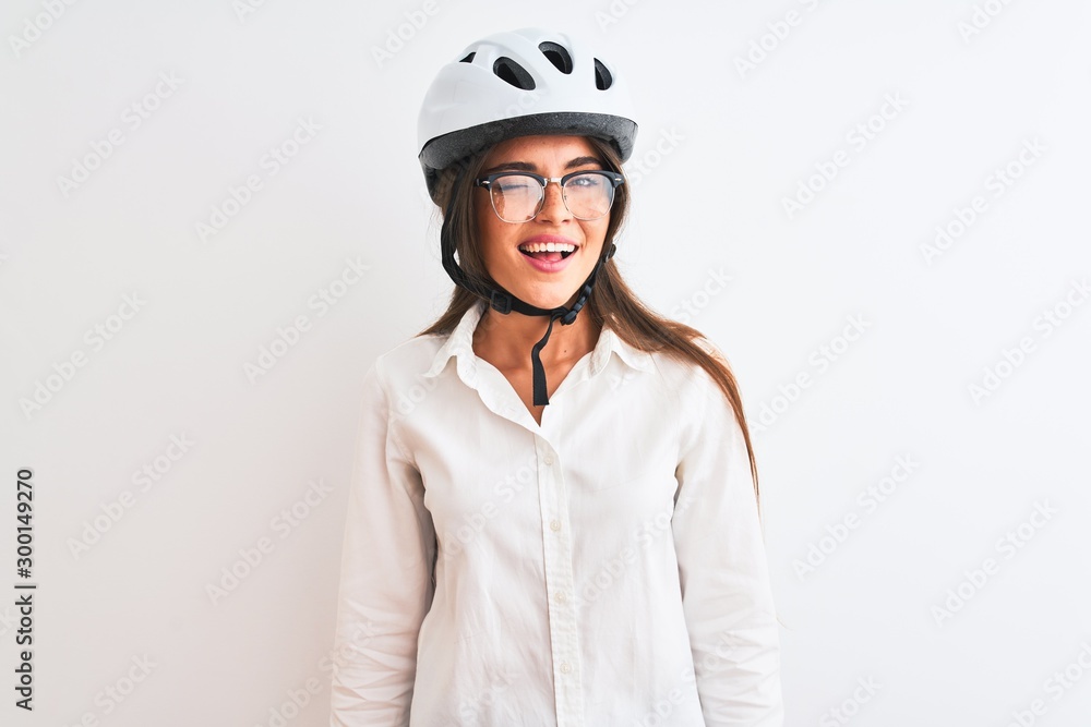 Beautiful businesswoman wearing glasses and bike helmet over isolated white background winking looking at the camera with sexy expression, cheerful and happy face. Beautiful businesswoman wearing glasses and bike helmet over isolated white background winking looking at the camera with sexy expression, cheerful and happy face.