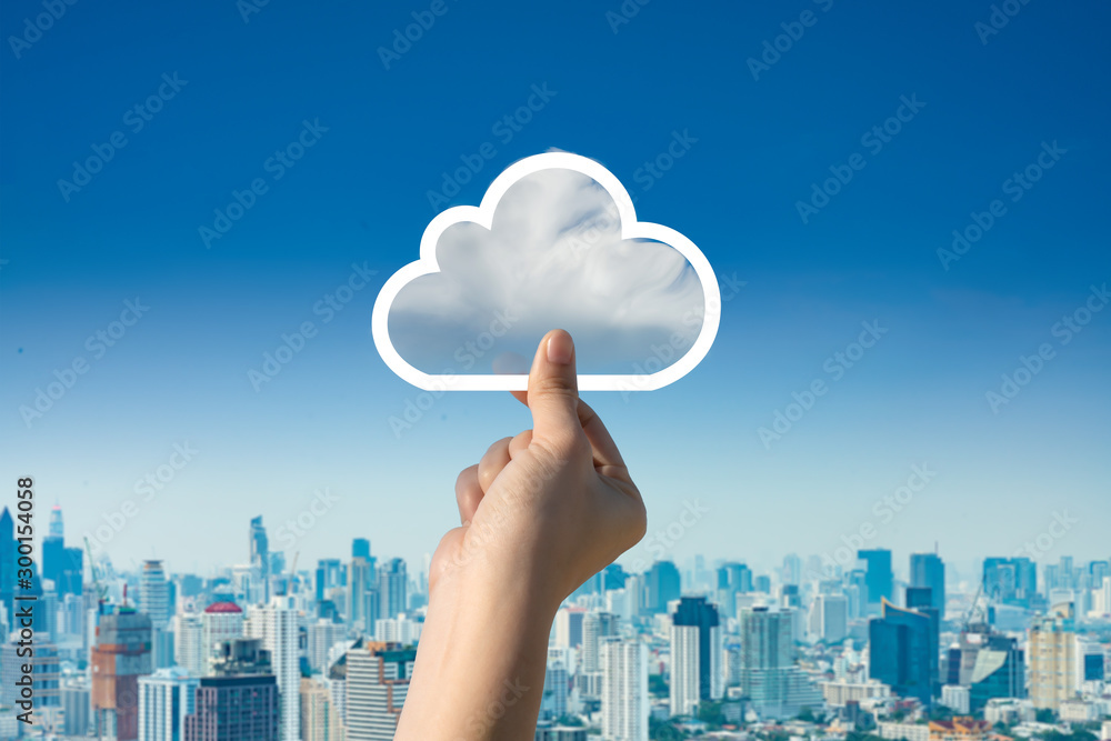 Concept of download on cloud storage.Woman hand holding picture on cloud sky background. The development of the imagination, copy space. - obrazy, fototapety, plakaty 