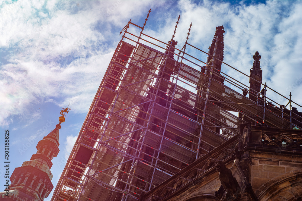 Fototapeta premium An ancient historical monument - Prague Castle, during the reconstruction surrounded by scaffolding at sunrise