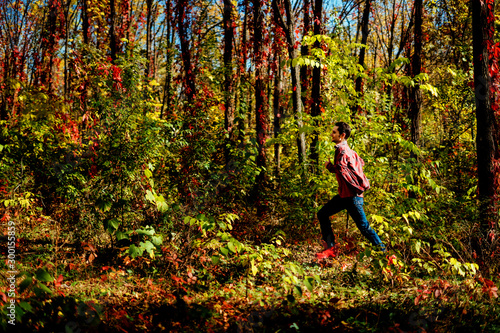Beautiful young man walking in forest in casual clothes