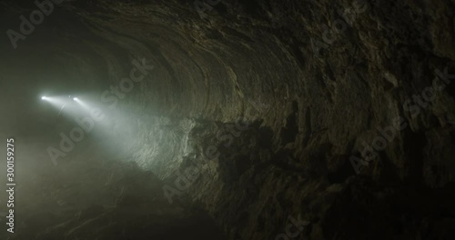 Reveal of two teammates on an adventure race team going through cave crane shot