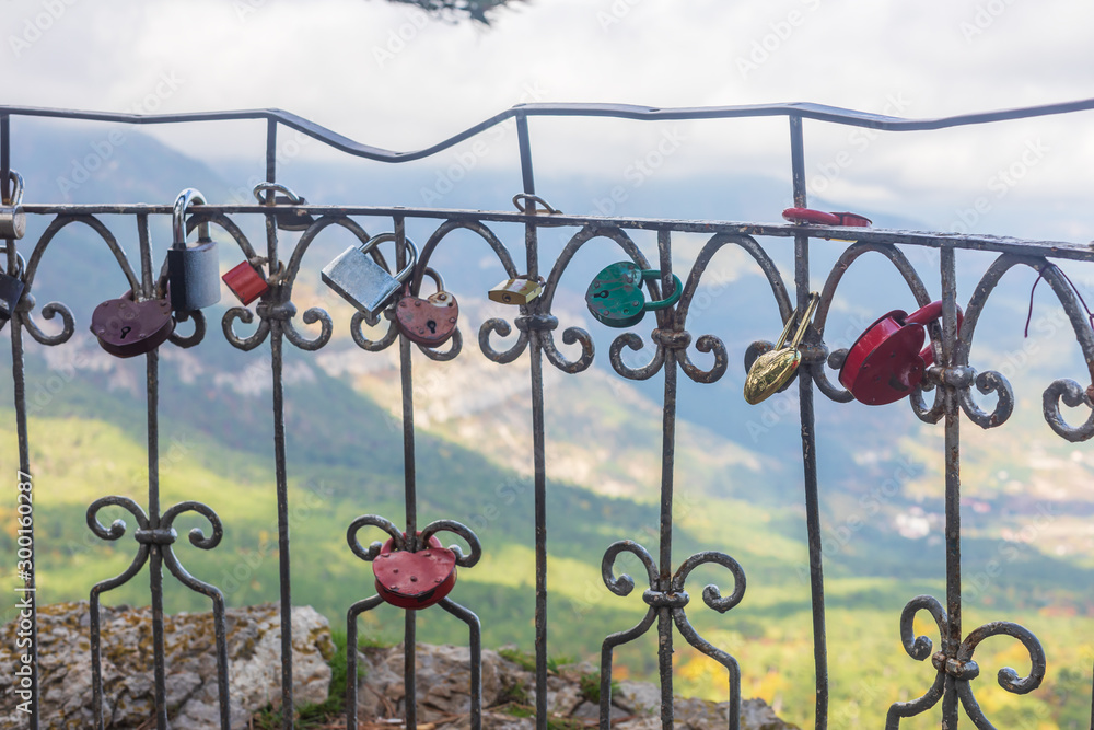 Love padlocks on fence. Different love locks on iron railing. Viewpoint Silver Arbor on road from Yalta to Ai-Petri Love padlocks on fence. Different love locks on iron railing. Viewpoint Silver Arbor on road from Yalta to Ai-Petri