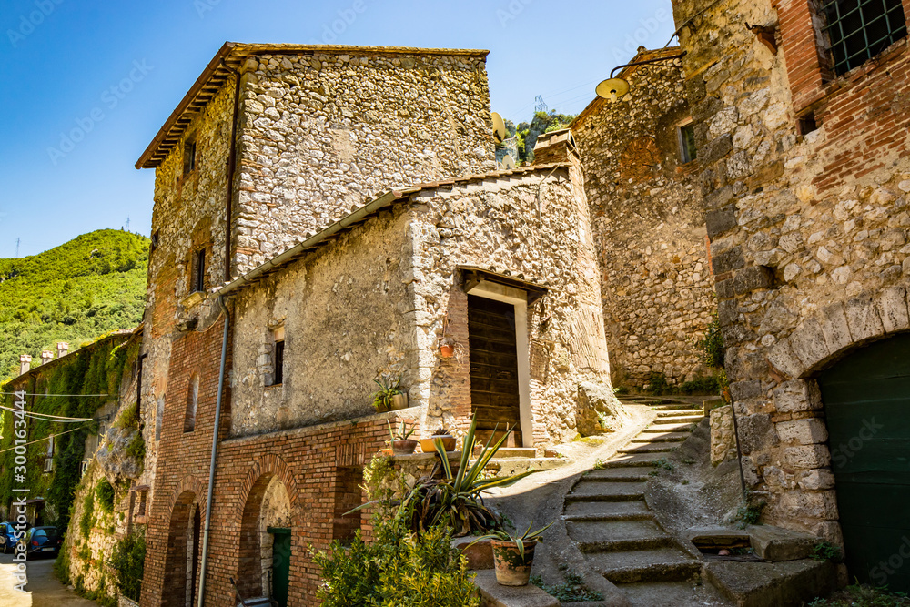 A glimpse of the small village of Stifone, on the Nera river. A cobblestone alley between the stone houses. A staircase. The walls of stones and bricks. Umbria, Terni, Italy