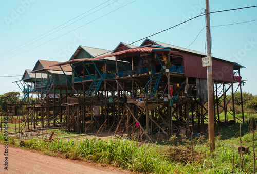 Floating village Residential houses on wooden poles and red soil road in Kampong Phluk Cambodia near Tonle Sap Lake © Vivid Cafe