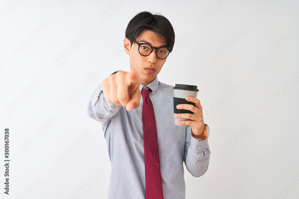 Chinese businessman wearing tie and glasses drinking coffee over isolated white background pointing with finger to the camera and to you, hand sign, positive and confident gesture from the front