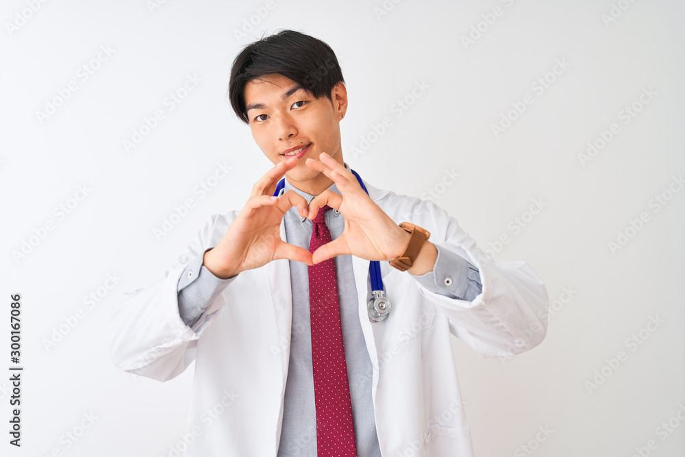 Chinese doctor man wearing coat tie and stethoscope over isolated white background smiling in love showing heart symbol and shape with hands. Romantic concept. Chinese doctor man wearing coat tie and stethoscope over isolated white background smiling in love showing heart symbol and shape with hands. Romantic concept.