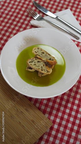 Pan y aceite de oliva sobre mantel de cuadros rojo