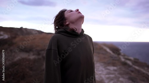 Portrait of a tired caucasian sportswoman in a sweatshirt at sunset. Concentration and determination before training