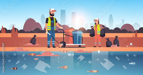 janitors gathering garbage and packing in black bags cleaners couple working together on beach area cleaning service environmental improvement concept river bank cityscape background horizontal vector