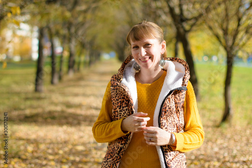 Portrait of a beautiful Russian woman 40 years old, in the autumn park.