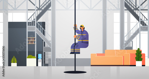 brave fireman sliding down the pole firefighter wearing uniform and helmet firefighting emergency service concept modern fire department interior flat horizontal full length vector illustration