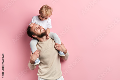 young father having nice time with his son. close up portrait, isolated puk background, photo