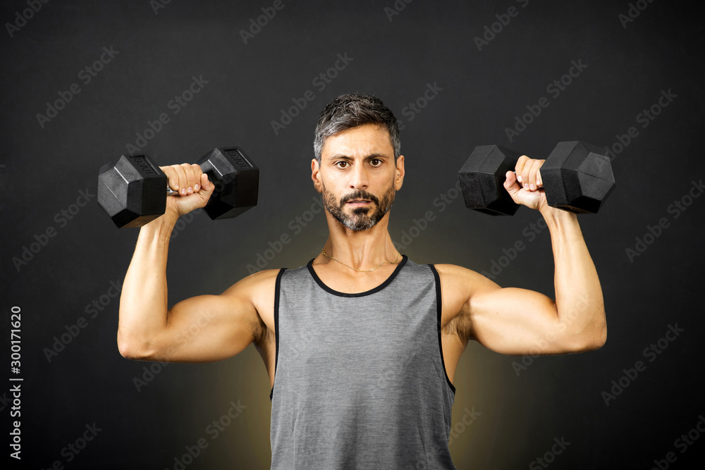 Fit muscular man weightlifting with dumbbells Fit muscular man weightlifting with dumbbells