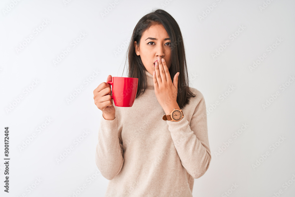 Beautiful chinese woman drinking red cup of coffee standing over isolated white background cover mouth with hand shocked with shame for mistake, expression of fear, scared in silence, secret concept Beautiful chinese woman drinking red cup of coffee standing over isolated white background cover mouth with hand shocked with shame for mistake, expression of fear, scared in silence, secret concept