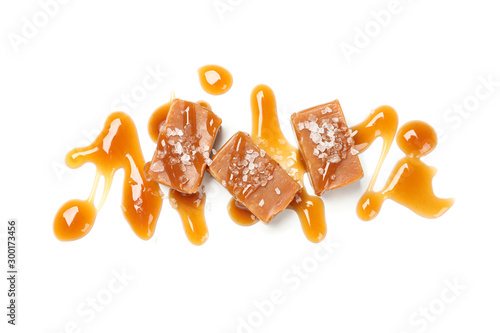 Obraz na plátně Salted caramel candies with sauce isolated on white background