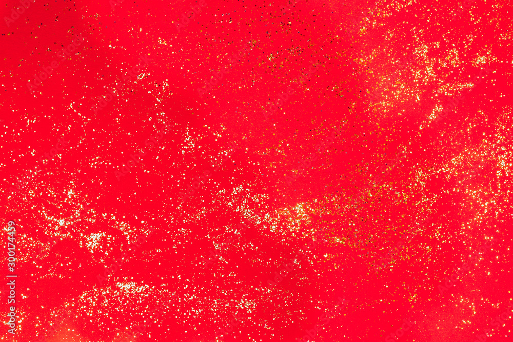 Golden glitter on red paper background. Christmas or Valentine's background. Flat lay Golden glitter on red paper background. Christmas or Valentine's background. Flat lay
