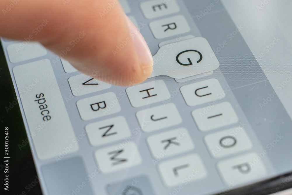 macro of a finger typing text on the touch screen keyboard of mobile device macro of a finger typing text on the touch screen keyboard of mobile device