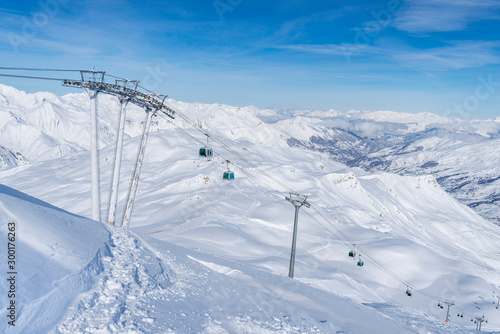 Gondola cable car lift against  mountains with lot of snow. © phototravelua