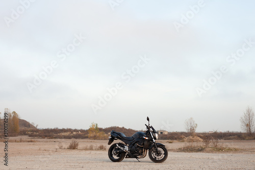 One black motorcycle in the desert. © sergeytay