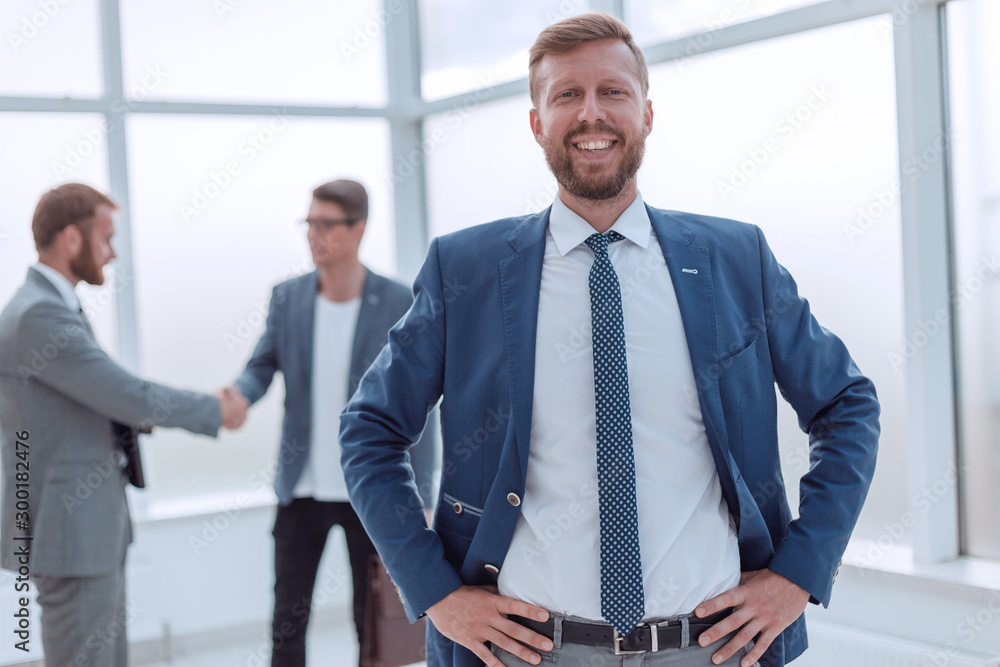 close up. successful business man standing in a bright office close up. successful business man standing in a bright office