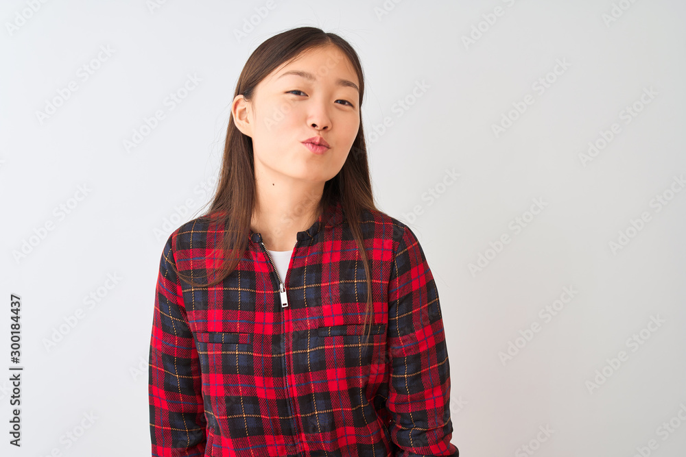 Young chinese woman wearing casual jacket standing over isolated white background looking at the camera blowing a kiss on air being lovely and sexy. Love expression.