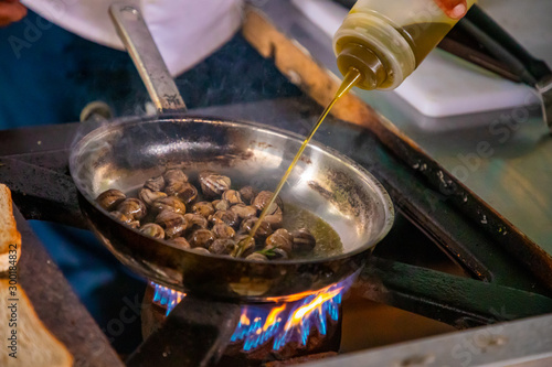 Cooking snails in a frying pan with fire in restaurant, Prague, Czech Republic