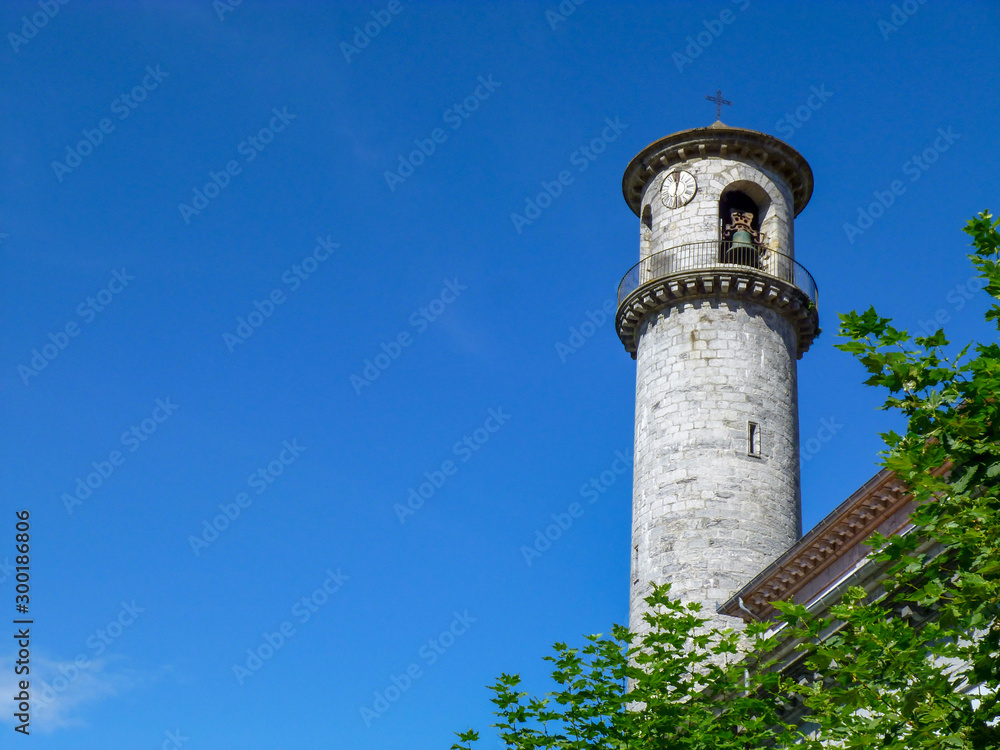 Church Tower with clock and bells on background of blue sky in Cantabria, Spain,  Europe