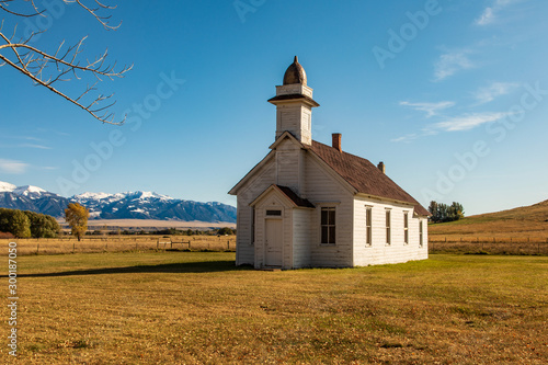 Church on open autumn field with snow top mountains background