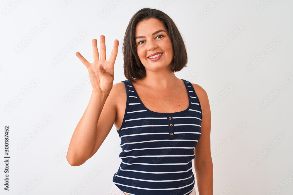 Young beautiful woman wearing blue striped t-shirt standing over isolated white background showing and pointing up with fingers number four while smiling confident and happy. Young beautiful woman wearing blue striped t-shirt standing over isolated white background showing and pointing up with fingers number four while smiling confident and happy.