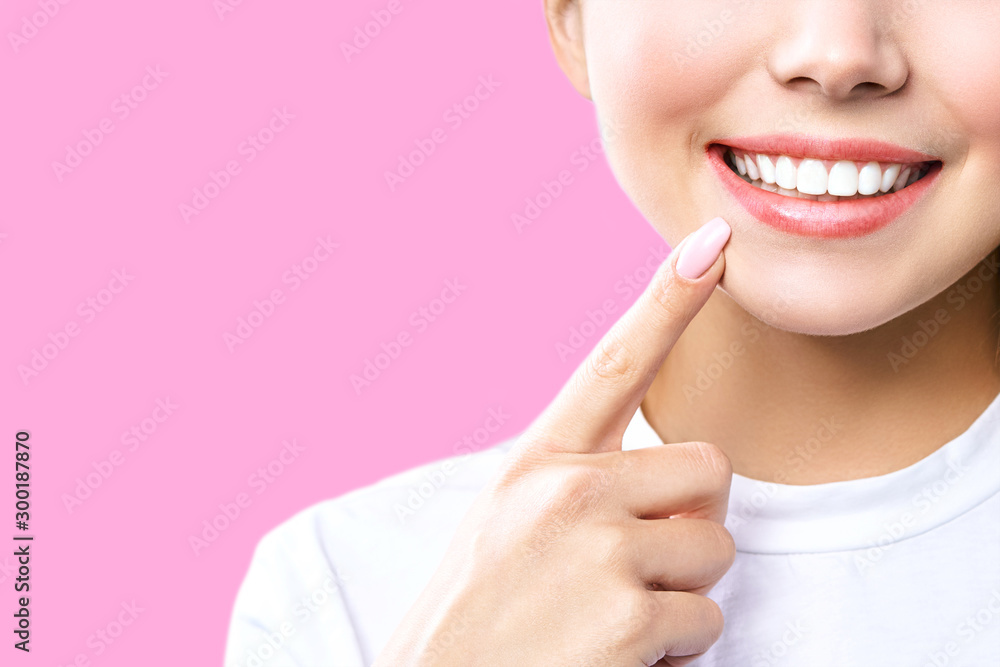 Perfect healthy teeth smile of a young woman. Teeth whitening. Dental clinic patient. Image symbolizes oral care dentistry, stomatology. Pink Background Perfect healthy teeth smile of a young woman. Teeth whitening. Dental clinic patient. Image symbolizes oral care dentistry, stomatology. Pink Background