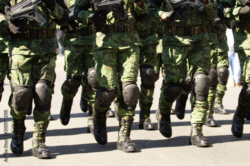 Foto a group of male soldiers marching holding assault guns, military boots, knee pro