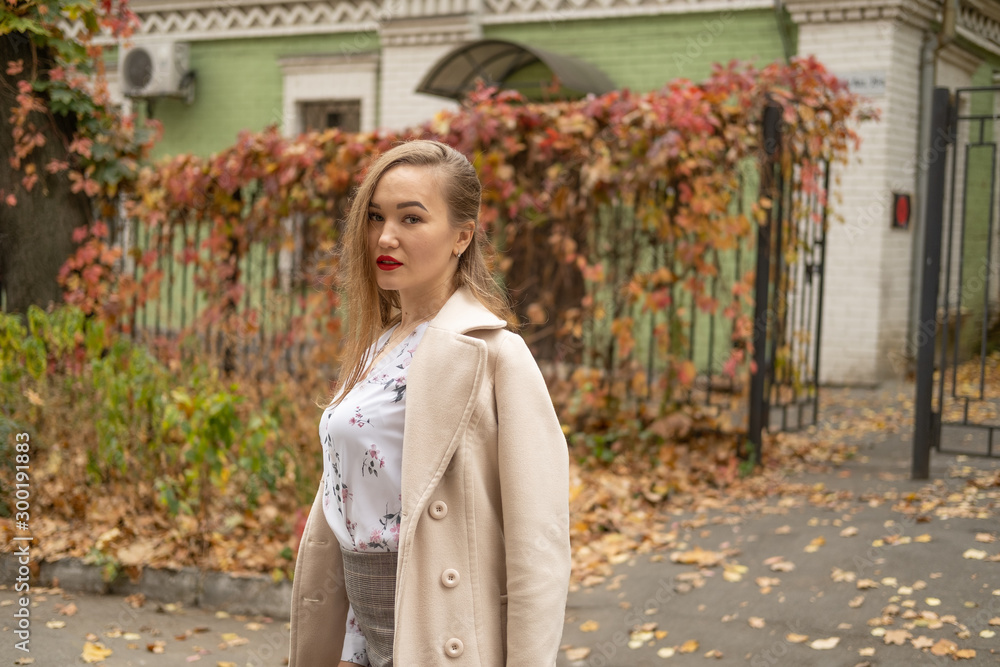 Street photo of young beautiful woman wearing stylish classic clothes. Model looking down. Full body portrait. Female fashion concept. Toned Street photo of young beautiful woman wearing stylish classic clothes. Model looking down. Full body portrait. Female fashion concept. Toned
