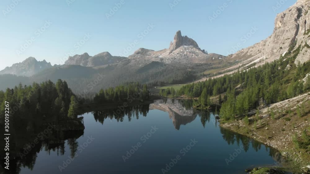 Drone aerial flying above mountain lake Lago Federa and pine forest near Croda da Lago ridge in Dolomites Italy at sunrise. Hiking nature epic landscape in South Tyrol. European Alps wanderlust. Drone aerial flying above mountain lake Lago Federa and pine forest near Croda da Lago ridge in Dolomites Italy at sunrise. Hiking nature epic landscape in South Tyrol. European Alps wanderlust.