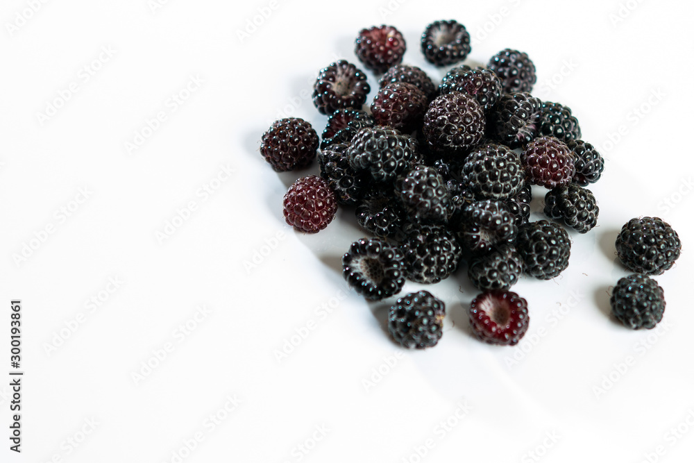 Black raspberry is fragrant and delicious on a white background.