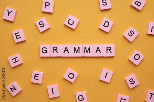 Grammar word wooden cubes on an yellow background.
