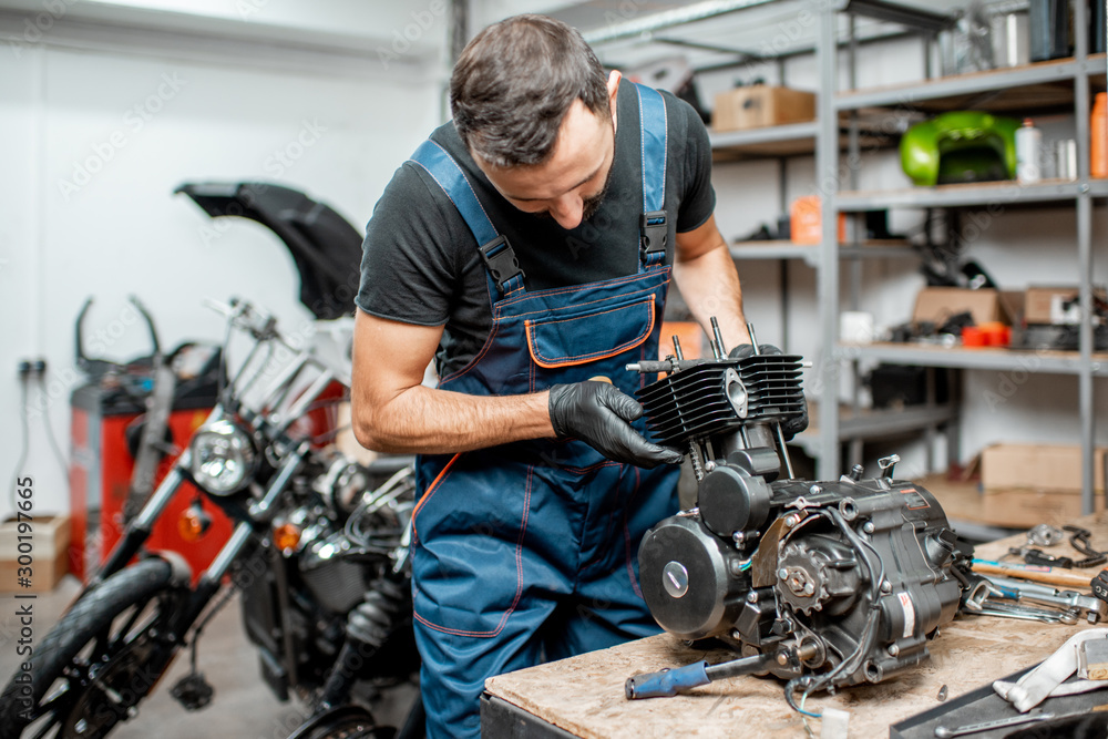Man repairing motorcycle engine Man repairing motorcycle engine