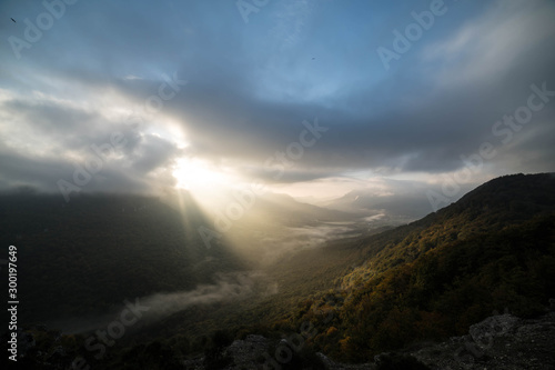 Cloudy dawn in an autumn green valley