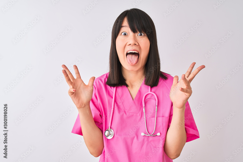 Young beautiful Chinese nurse woman wearing stethoscope over isolated white background celebrating crazy and amazed for success with arms raised and open eyes screaming excited. Winner concept Young beautiful Chinese nurse woman wearing stethoscope over isolated white background celebrating crazy and amazed for success with arms raised and open eyes screaming excited. Winner concept
