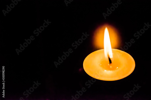 Single lit up candle with flame and give the feeling of peace.of mind.