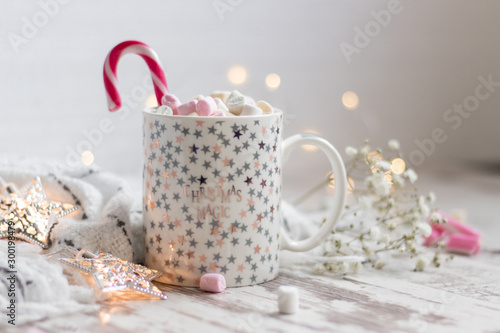 christmas cup with marshmallow, handmade snowflakes, led stars on wooden backdrop