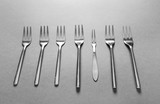Different forks on grey background. Uniqueness concept