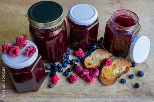 Homemade berries jam with toast on wooden table