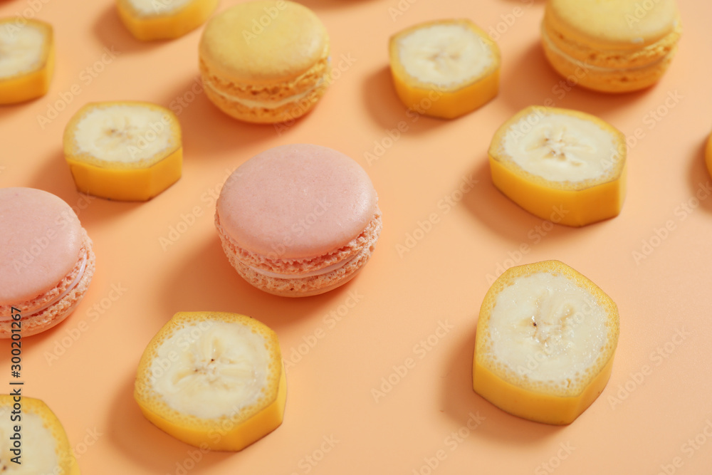 Tasty macarons with banana slices on color background Tasty macarons with banana slices on color background