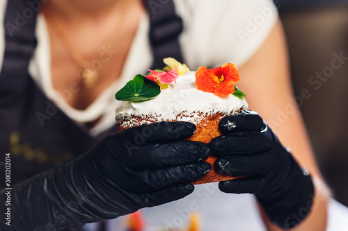 Confectioner decorates Easter cake with delicate flowers. photo