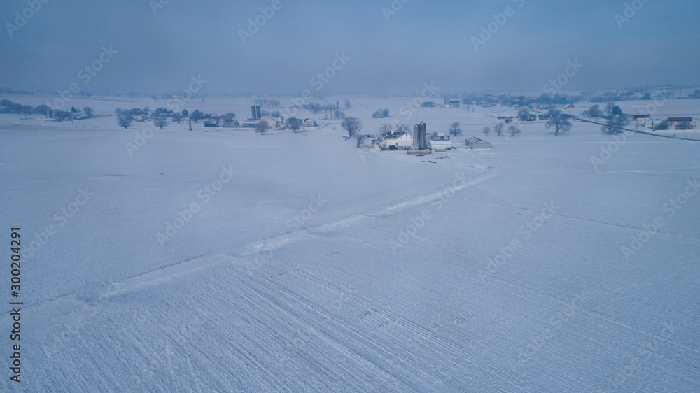 Aerial View of Fresh Followed Morning Snow over an Amish Countryside and Farm Land as Seen by a Drone